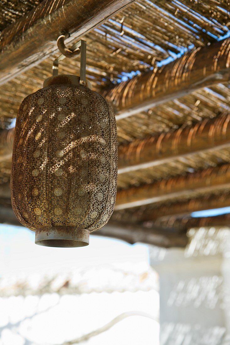 Oriental lantern below shady wooden pergola