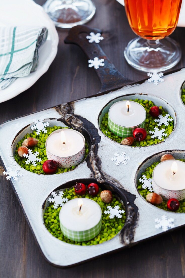Grosses Muffinblech als Kerzenständer mit Nüssen und weihnachtlicher Deko