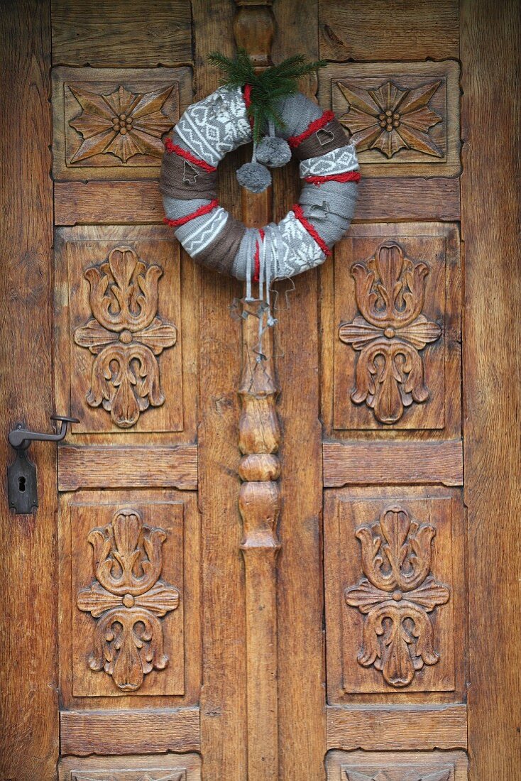 Hand-made, festive wreath on carved wooden door