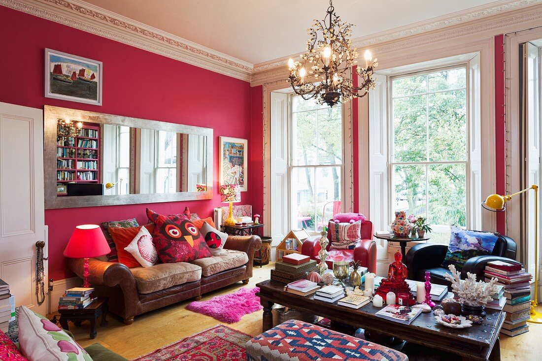 Pinkfarbene Wände in herrschaftlichem Raum mit großem, langen Wandspiegel, Ledercouch und raumhohen Fenstern