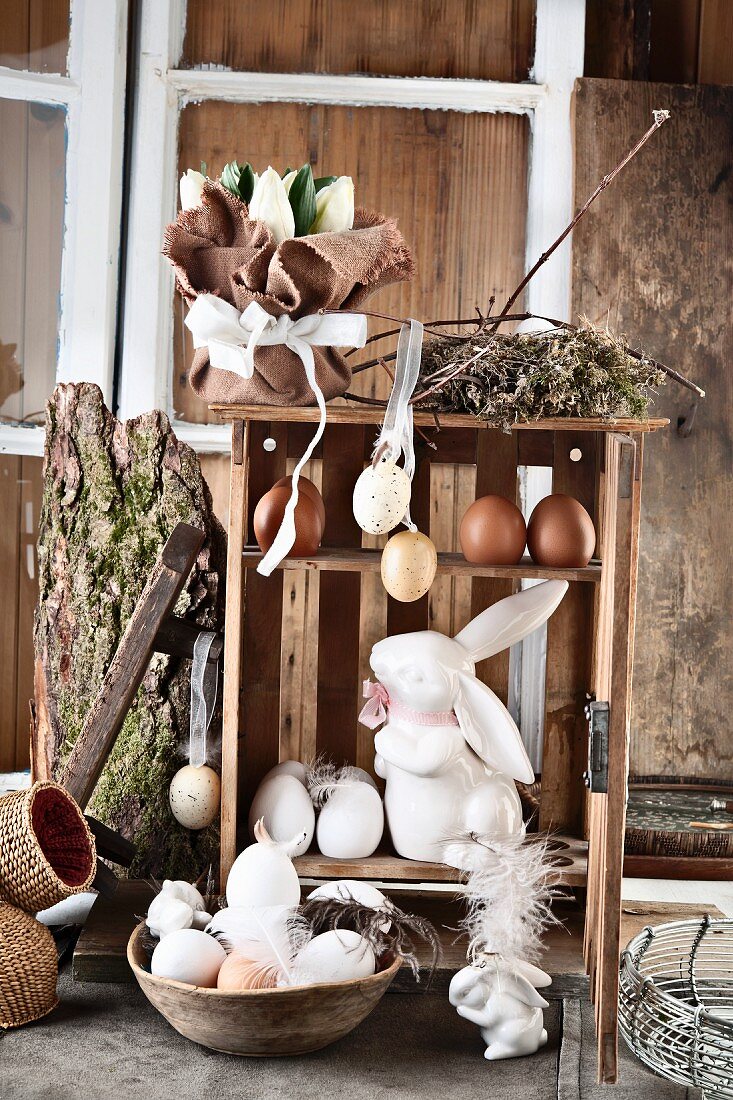 An antique egg box made of wood, with eggs and a porcelain hare