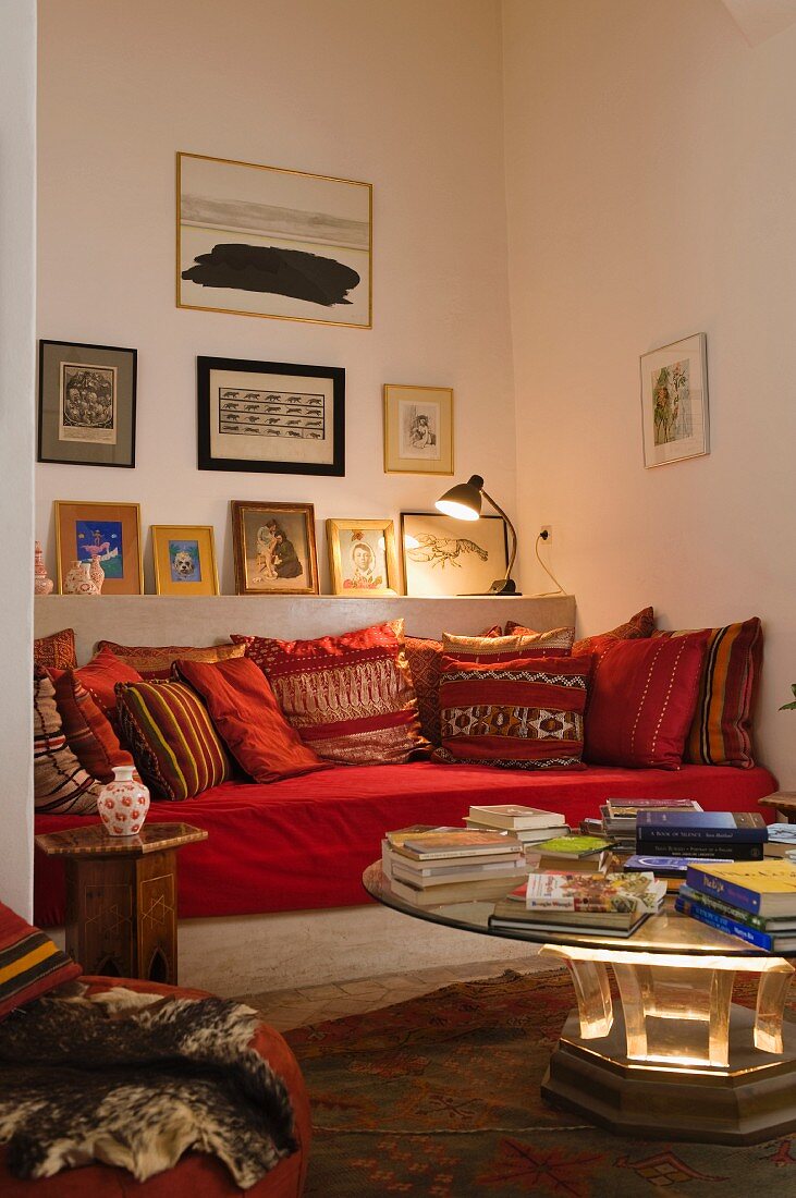 Moroccan seating area in niche with gallery of pictures above masonry couch