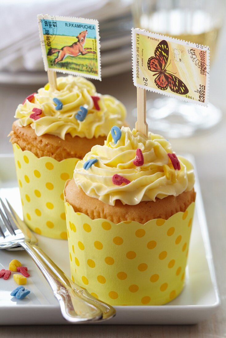 Cupcakes decorated with flags made from postage stamps