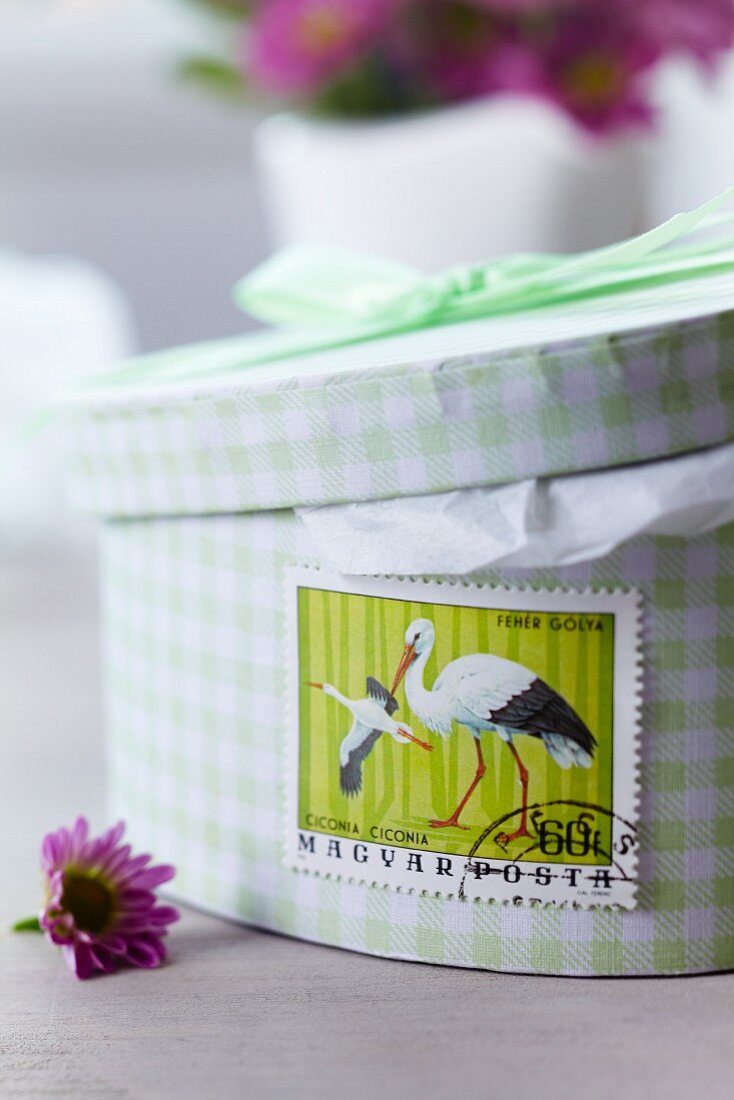 Schachtel beklebt mit Storch-Briefmarke als Geschenk zur Babyparty