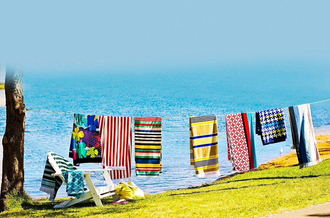 Bunte Badetücher auf einer Wäscheleine am Strand
