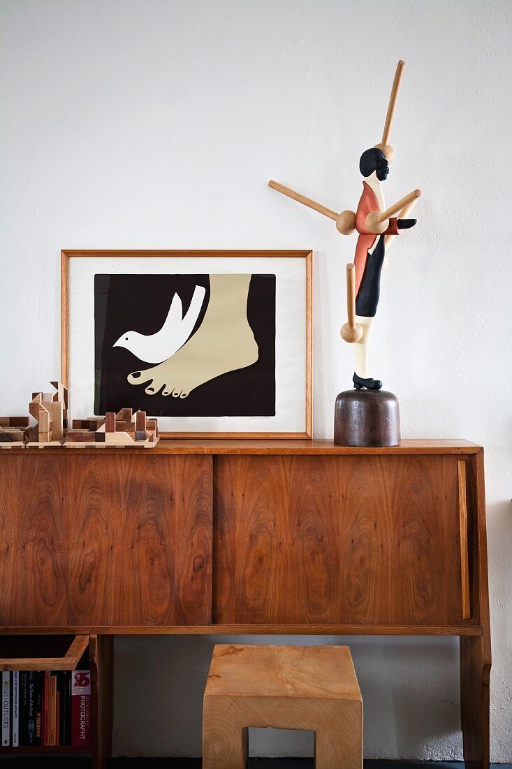 Framed picture (illustration) and wooden sculptures on 60s sideboard