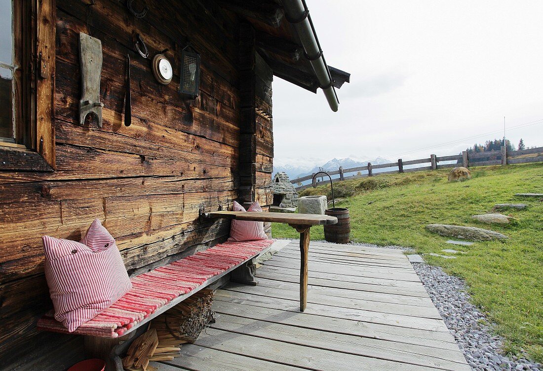 Rustic bench in front of Alpine cabin