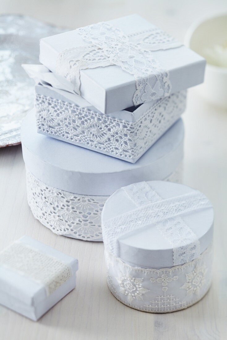Cartons decorated with white lace trim as romantic gift boxes
