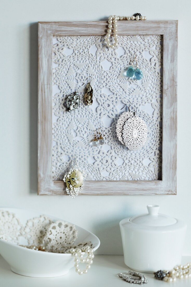 Crocheted doily in picture frame used as jewellery rack