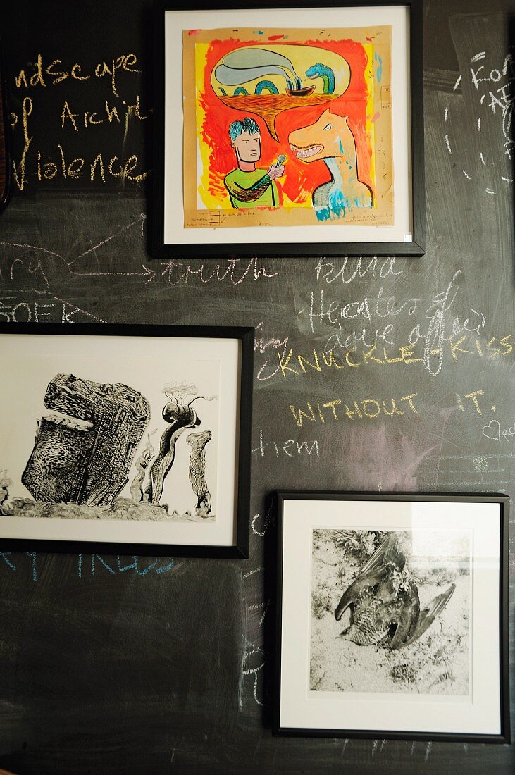 Framed photos and drawings mounted on blackboard with writing