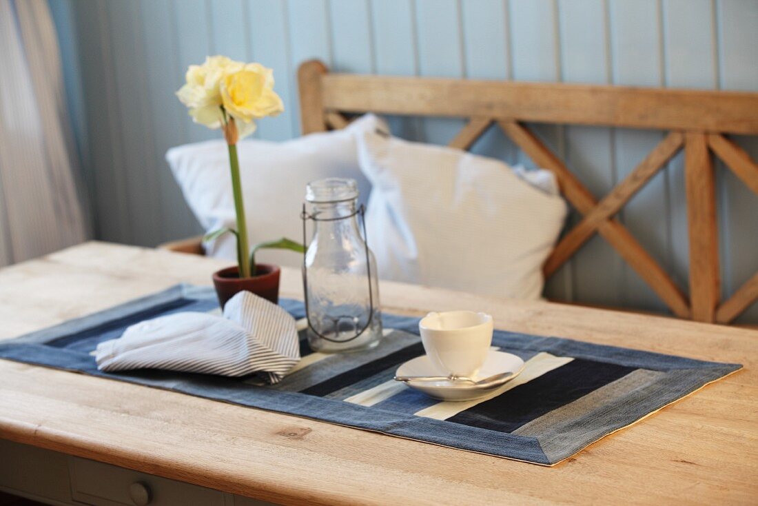 Kaffeetasse und Blumentopf auf selbstgenähtem Tischläufer