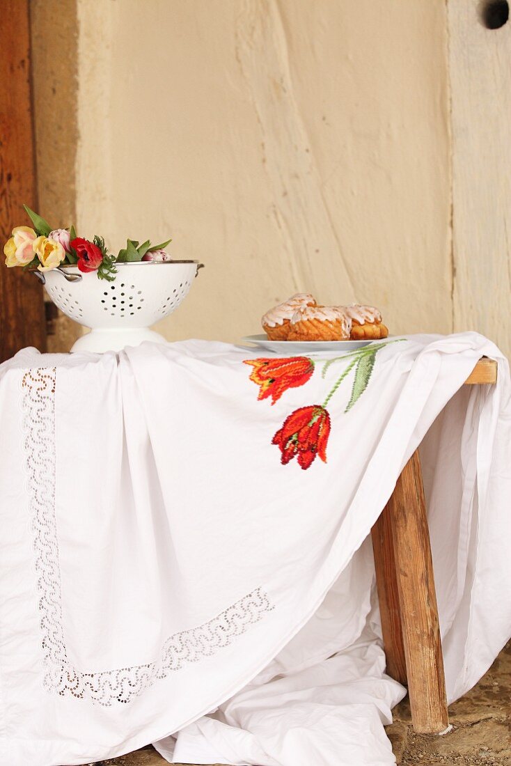 Tablecloth embroidered with floral motif on wooden table