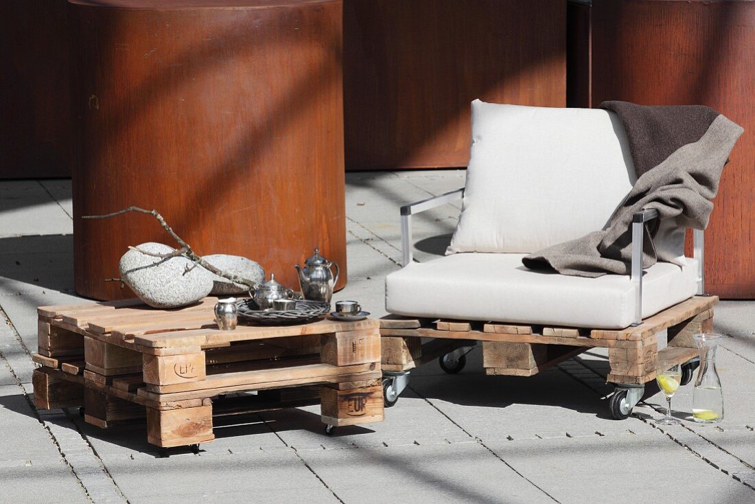 Selbstgebauter Couchtisch und Sessel aus Holzpaletten auf Terrasse