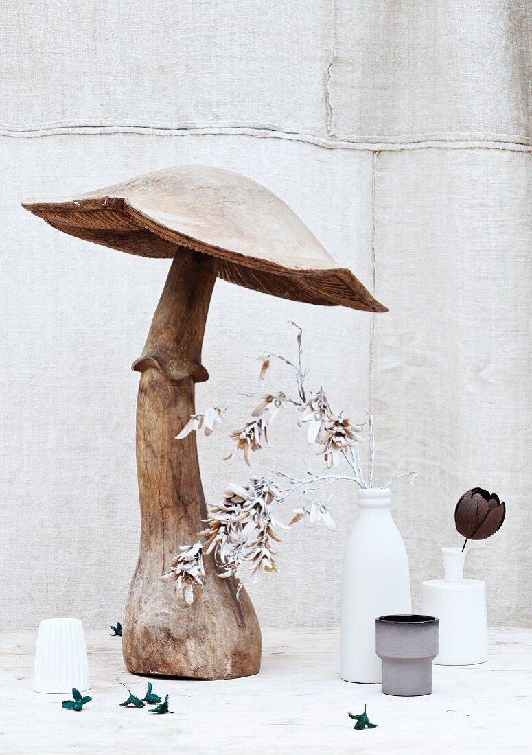 Large, wooden mushroom ornament and painted plants in vases