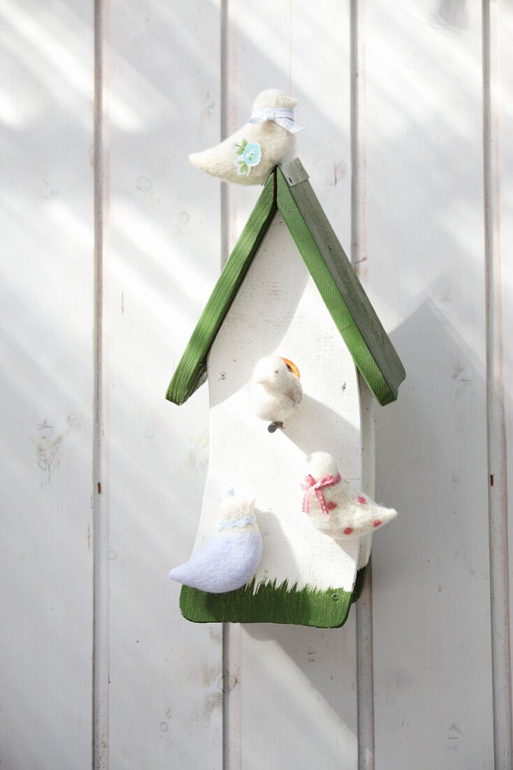 Wooden birdhouse with hand-crafted birds made from undyed wool felt
