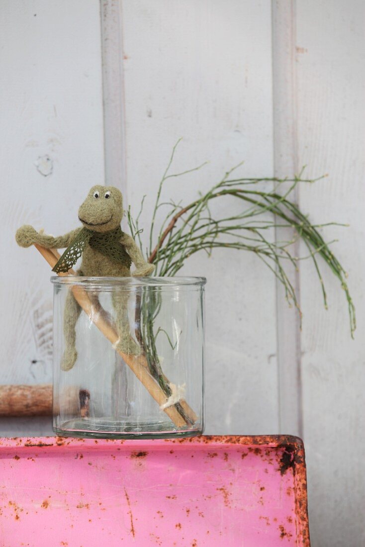 Hand-felted frog on ladder made from sticks in glass vase