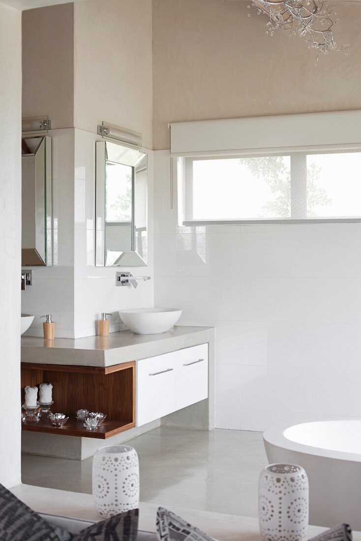 Übereck-Waschtisch mit gerahmten Spiegeln und integriertem Holzregal in hellem Bad mit poliertem Zementboden