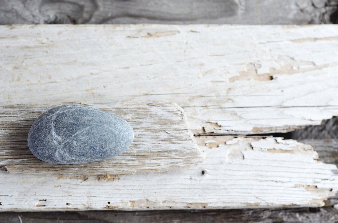 Grey stone on weathered wooden board