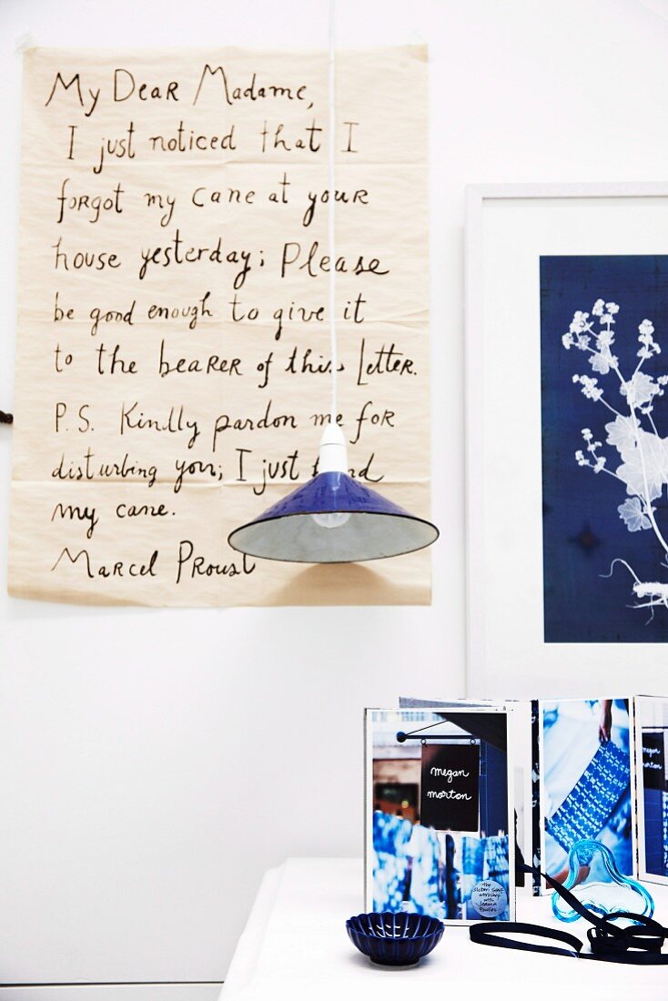 Vergrößerter handgeschriebener Brief als Wanddekoration vor blauer Pendelleuchte