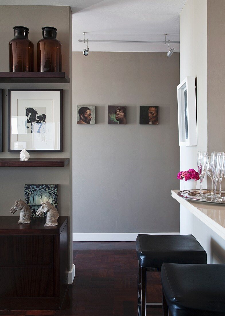 Kitchen counter, black leather stools and horses-head ornaments on sideboard