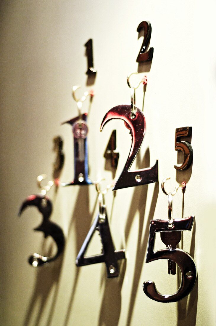 Zimmerschlüssel mit Metallzahlen an einer Wand