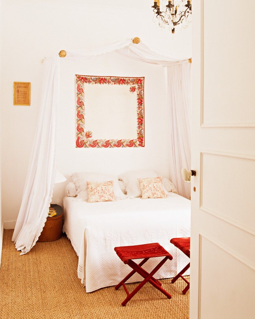 Blick durch geöffnete Tür in Schlafzimmer mit Doppelbett, Baldachin & Sisalteppichboden