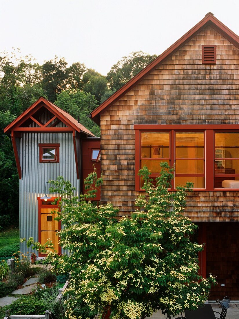 Moderner Landhausstil - Haus mit Holzschindelfassade und Anbau mit Wellblechwand