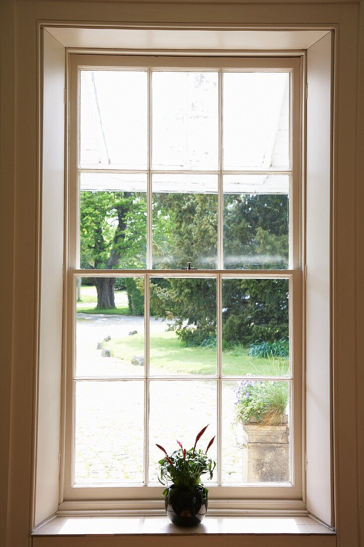 Blick durch Sprossenfenster in sommerlichen Garten