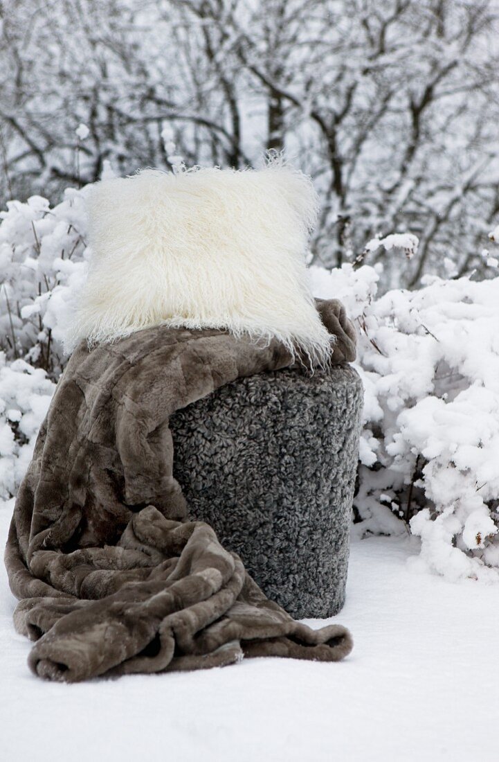 Fur blanket and flokati cushion in snow