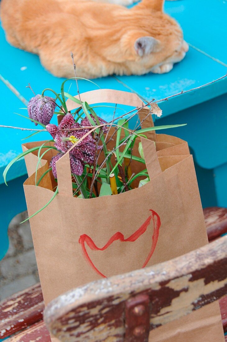 Flower arrangement of snake's head fritillaries in paper bag