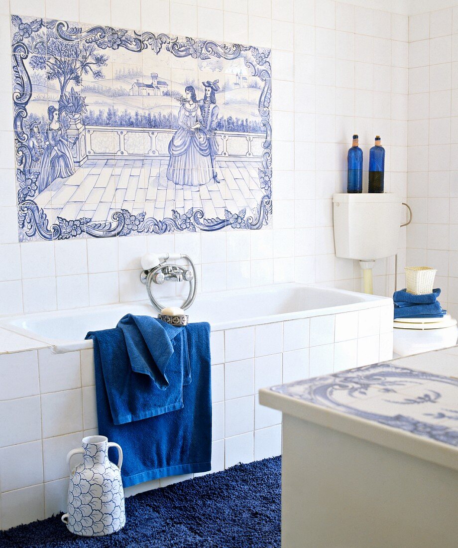 Weisses Bad mit Accessoires in kräftigem Blau und altem Fliesenbild über der Badewanne im zartblauen, klassischen Delfter Muster