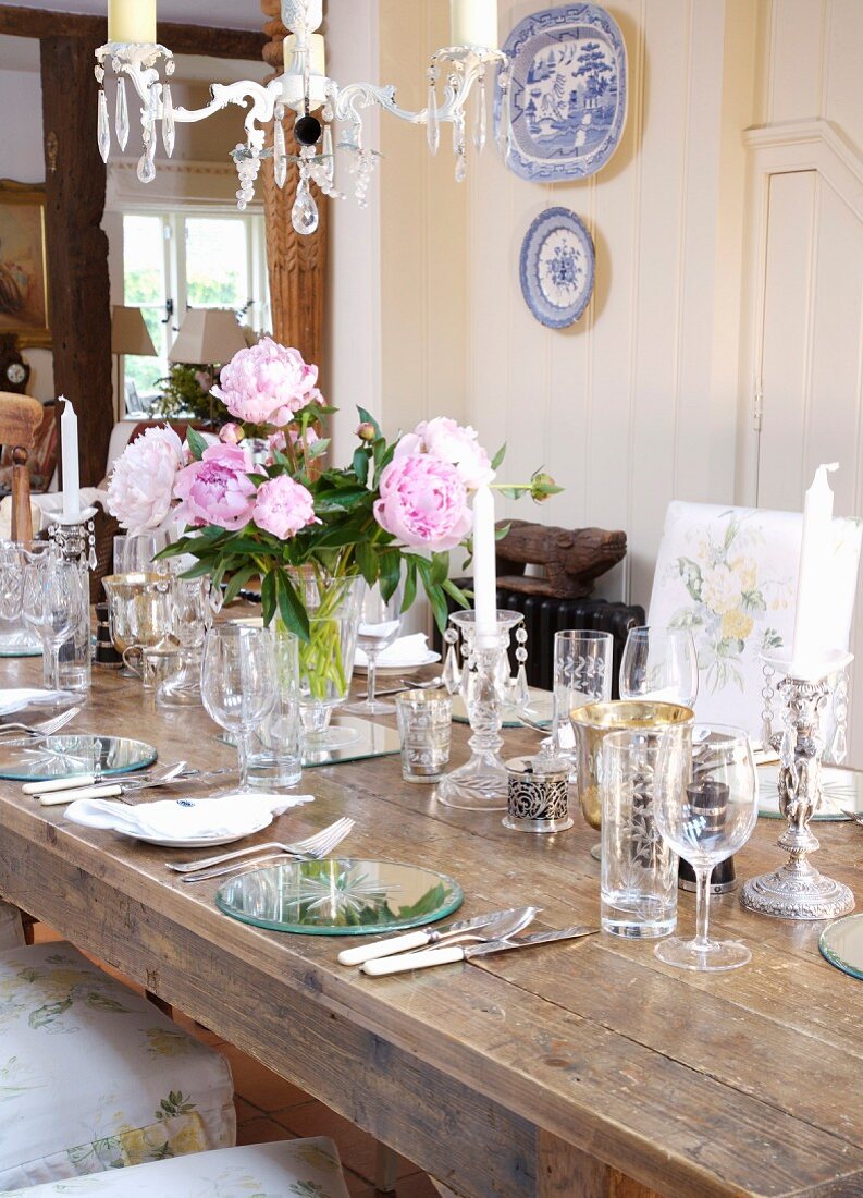 Rustikaler Tisch mit Gedecken und verschiedenen Gläsern in ländlichem Esszimmer