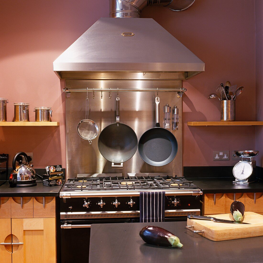 Gasherd im Vintagelook mit Edelstahl Dunstabzug an violett getönter Wand in moderner Küche