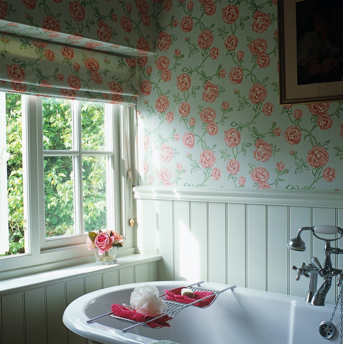 Vintage Badewanne vor Fenster im Badezimmer mit gleichem Rosenmuster auf Rollo und Tapete