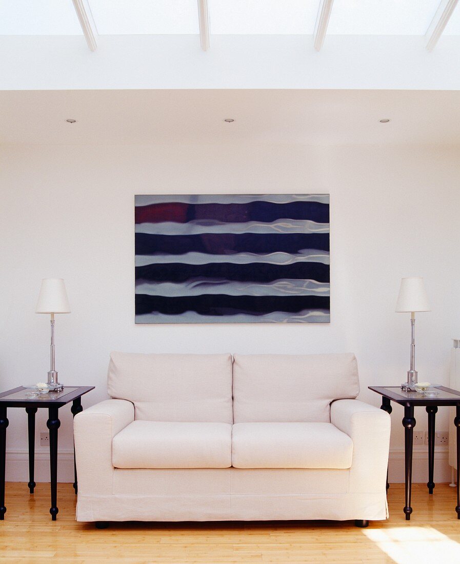 Couch mit zwei Beistelltischchen, Tischleuchten, Wandbild & Deckenfenstern