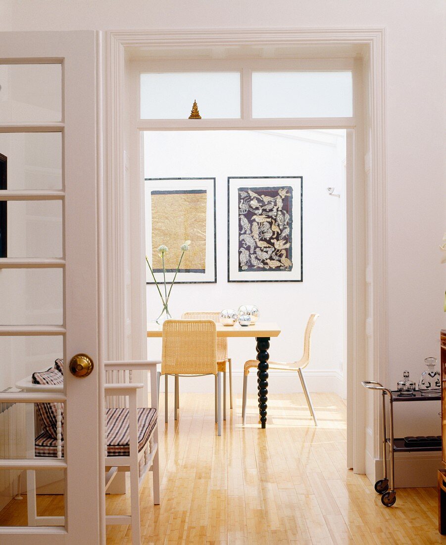 Blick in Esszimmer mit Wandbildern, stühlen & Esstisch mit gedrechselten Tischbeinen