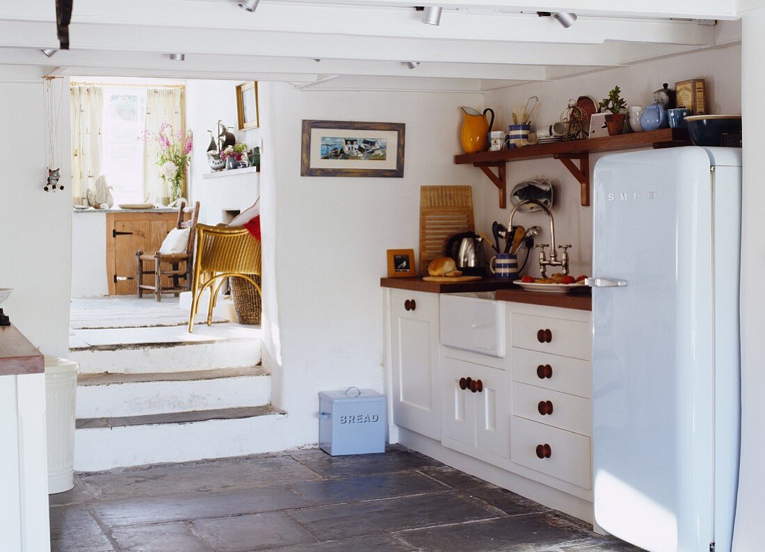 Landhausküche mit niedriger Holzdecke & Zugang über Treppenstufen zum Wohnraum