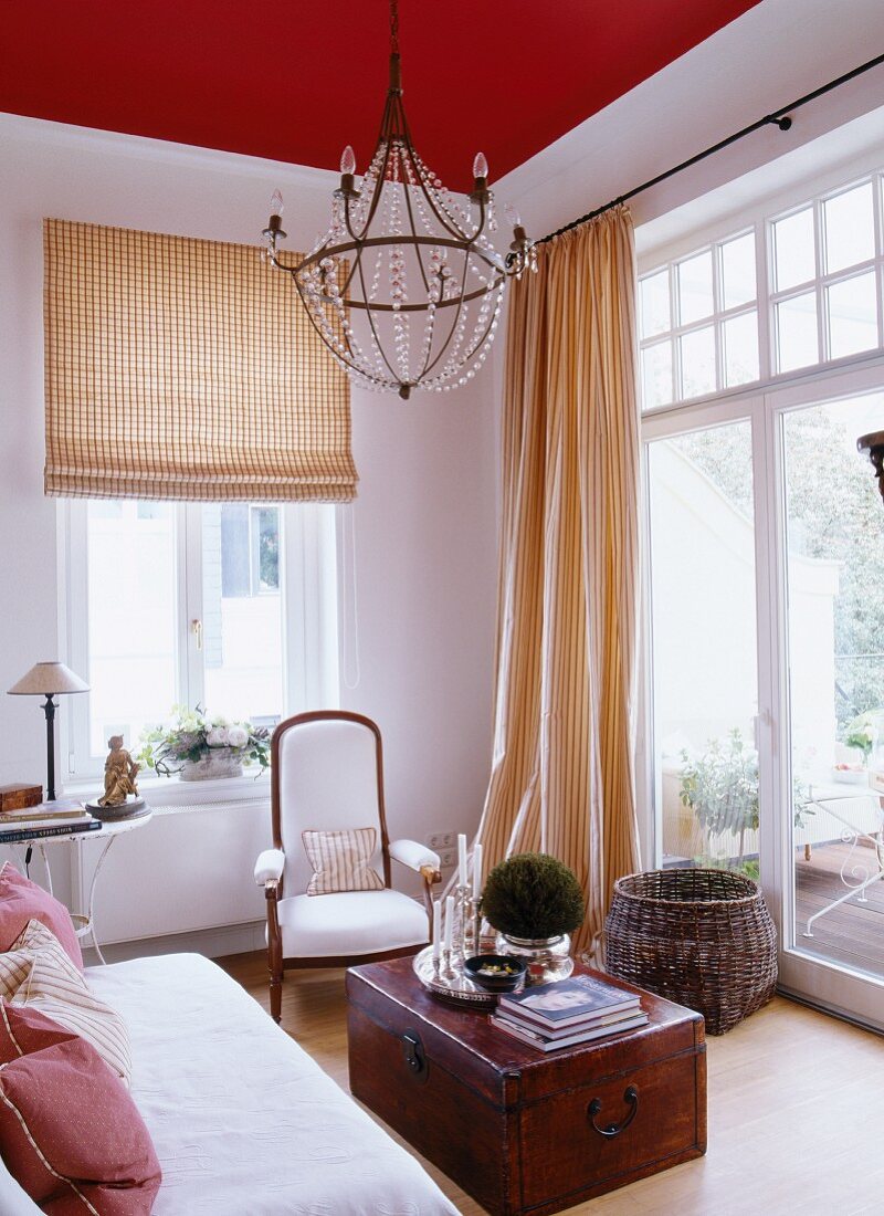 Wohnzimmer mit roter Decke & antike Holztruhe als Wohnzimmertisch