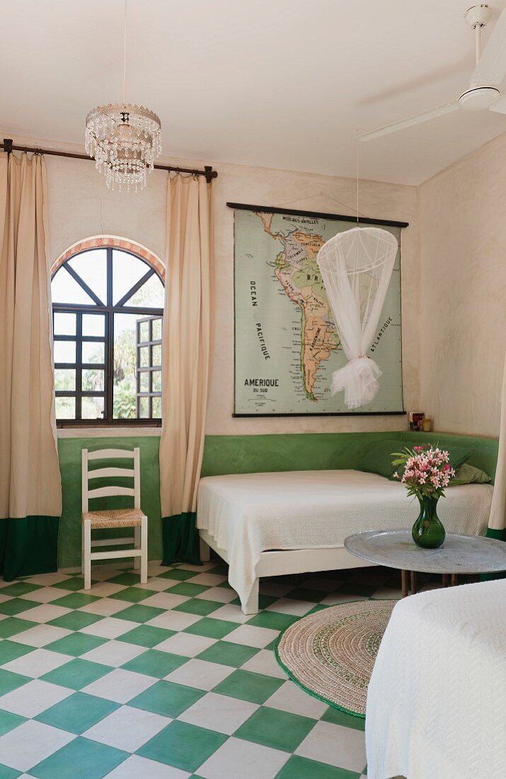 Green and white chequered floor in bedroom with twin beds and arched window