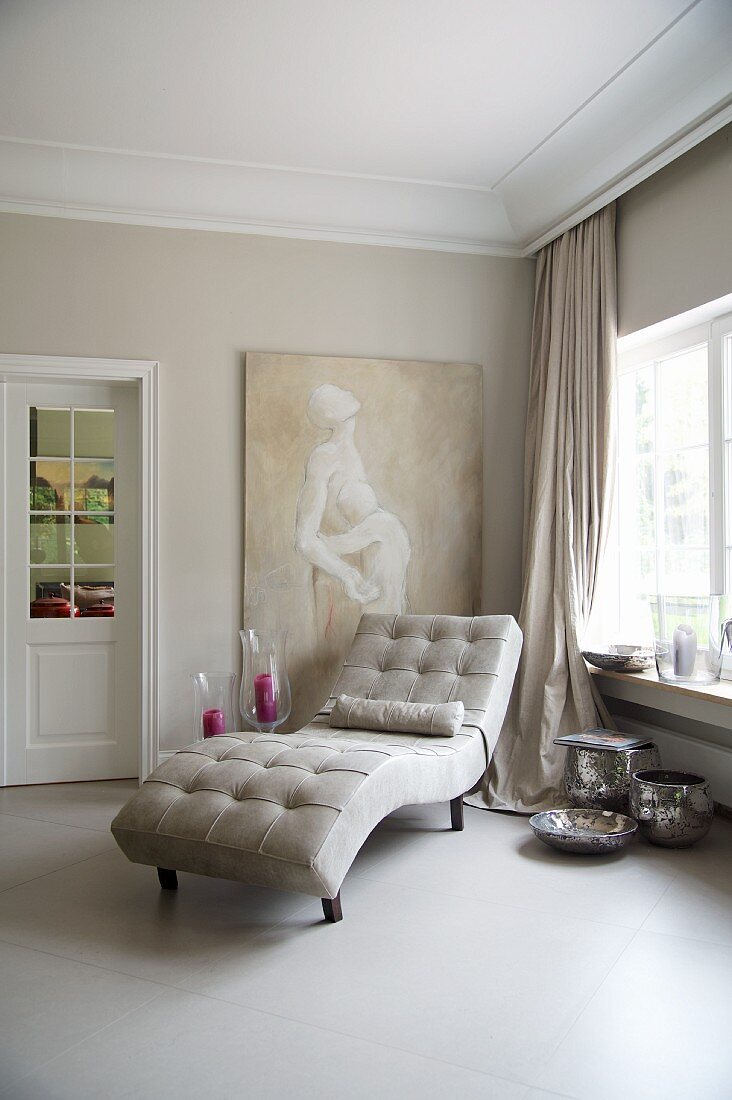 Pale leather chaise longue in room with large ceramic floor tiles