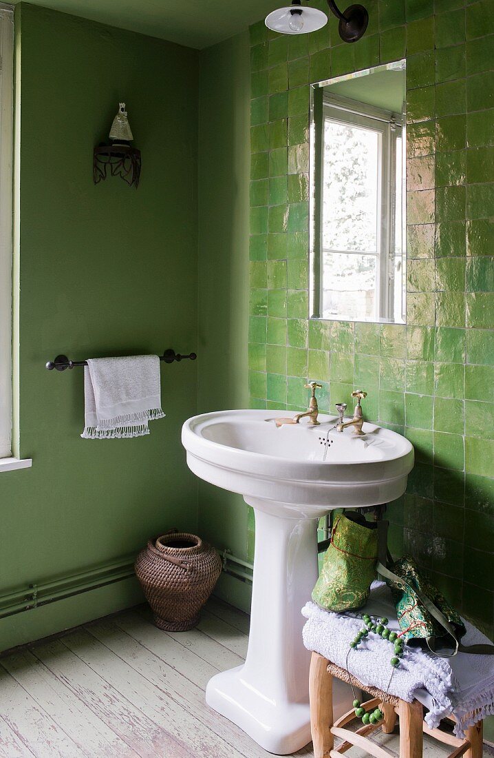 Green bathroom with pedestal sink & tiled wall