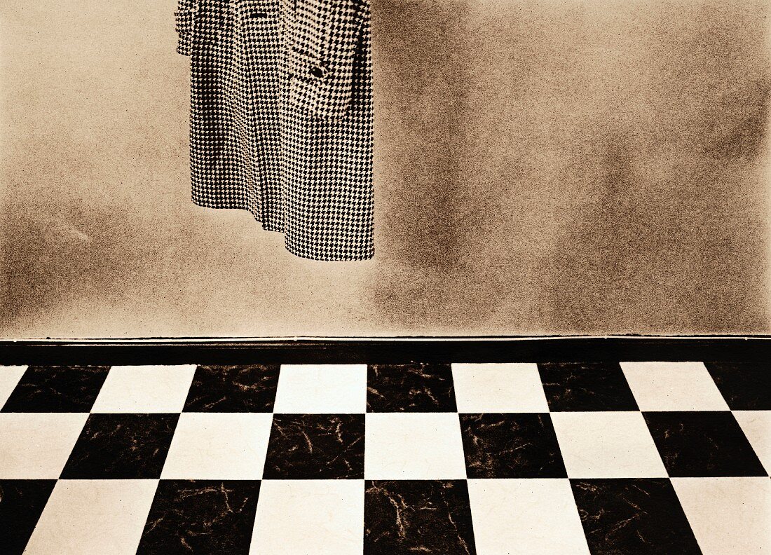 Coat hanging above chequered floor