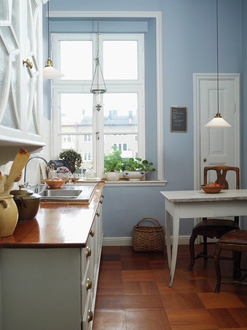 Himmelblau getönte Wohnküche im traditionellen skandinavischen Stil mit alten Glaspendelleuchten