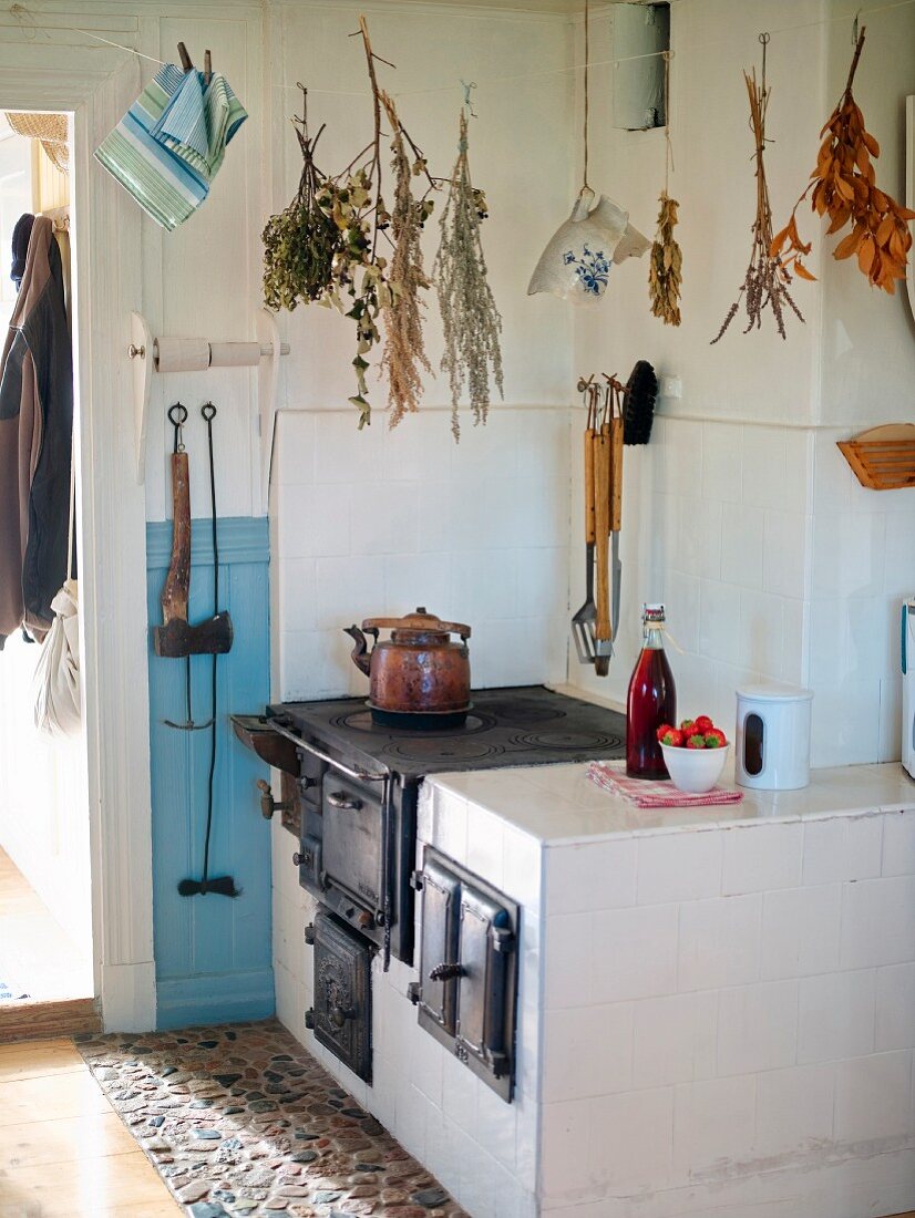 Trockensträusse über altem, gemauertem Küchenofen mit gusseisernem Herd
