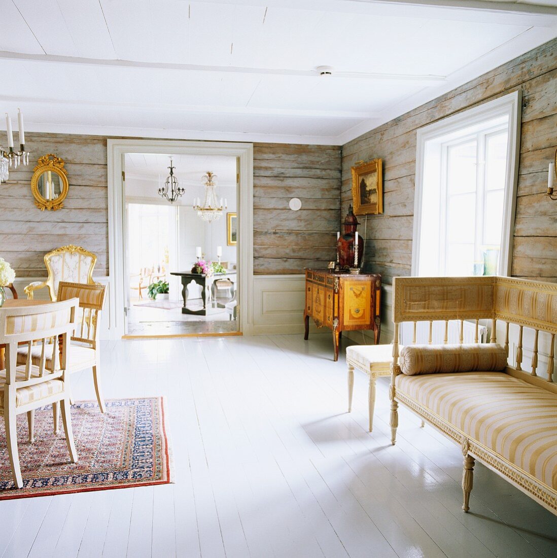 Connected rooms in old, Swedish, wooden house with original, rustic wooden walls and antique furnishings
