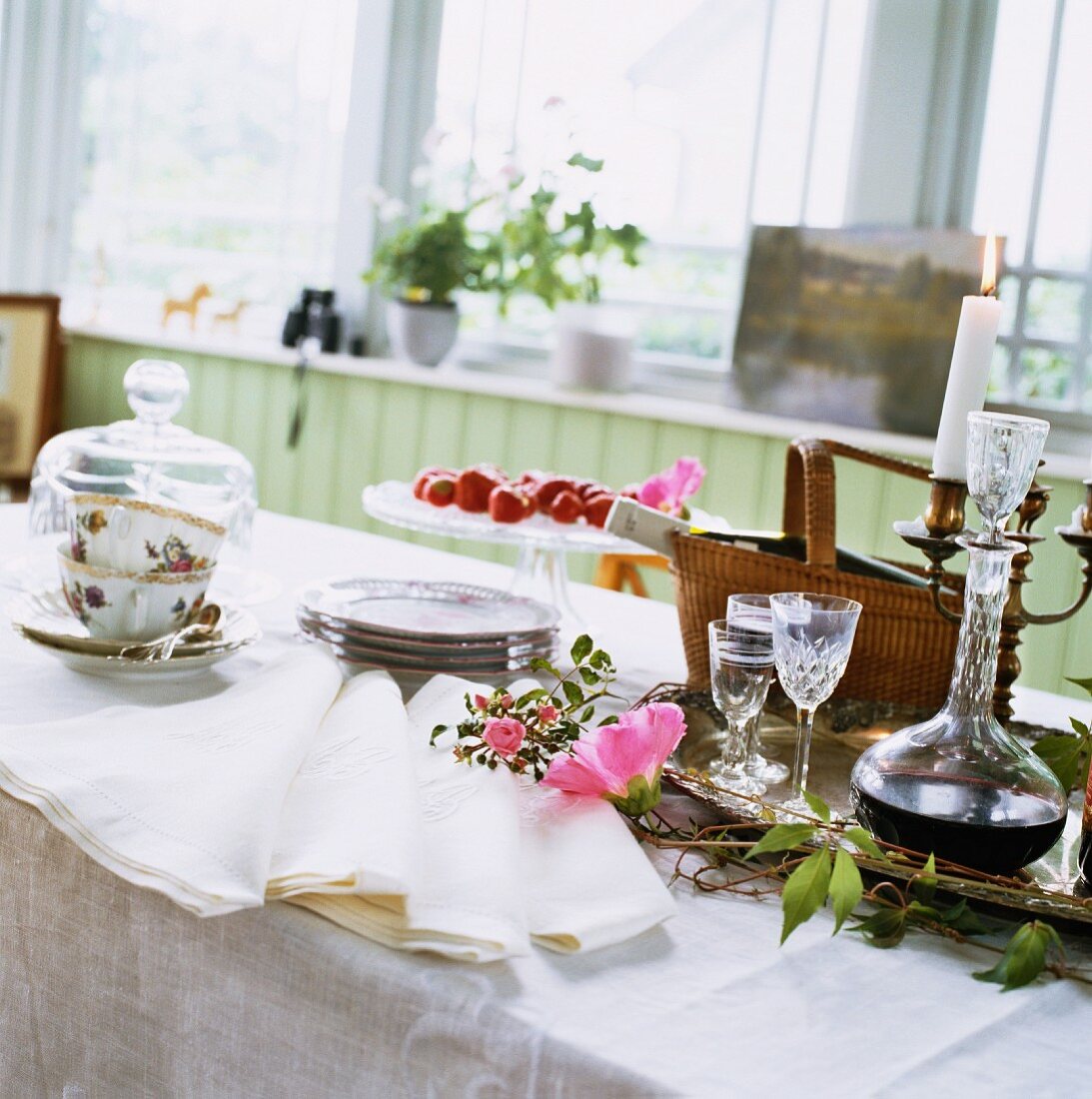 Weiß gedeckter Tisch mit Kaffeegeschirr und Likörkaraffe aus Kristallglas