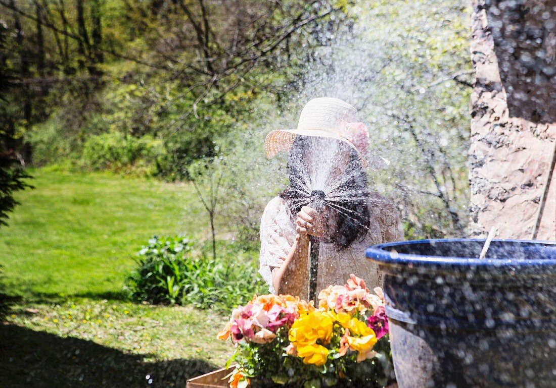 Woman spraying water towards camera