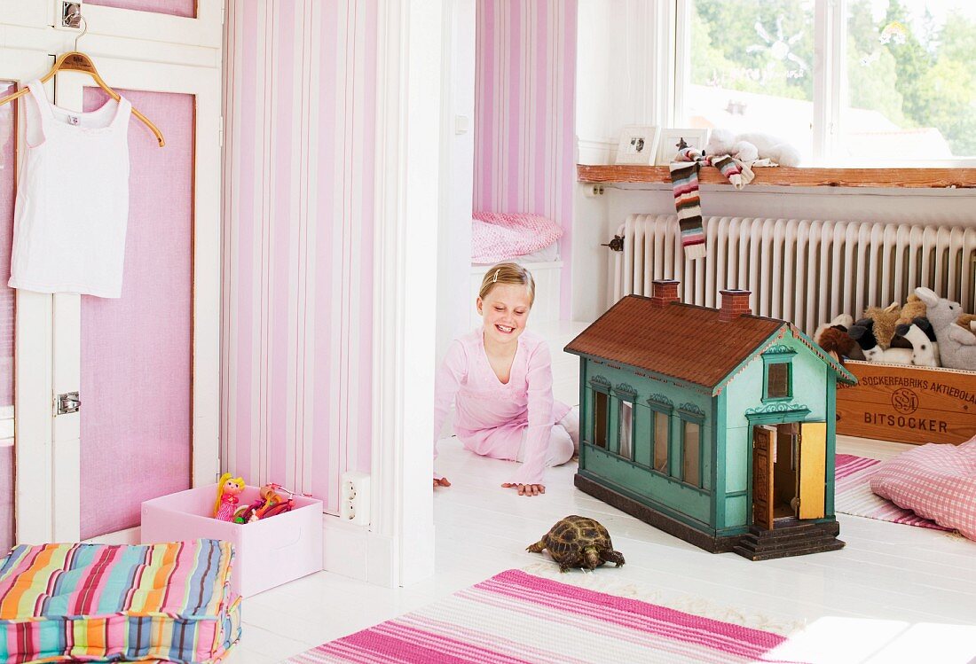 A girl and a tortoise in a children?s room.