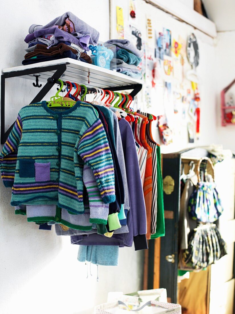 Garderobe in Kinderzimmer mit daran hängender Kinderkleidung