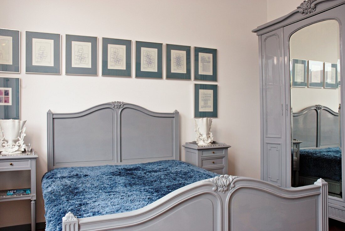 Grey, nostalgic furniture and framed pictures in bedroom